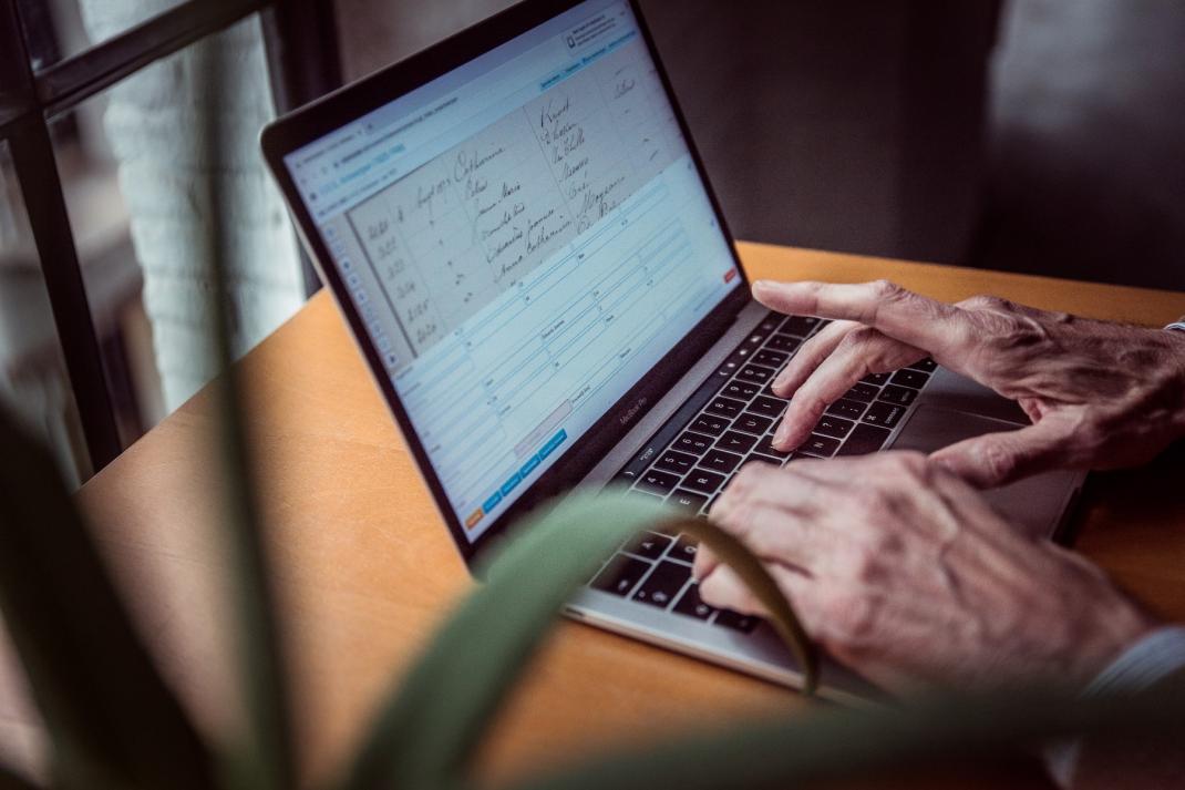 Handen schrijven historisch handschrift over op laptop