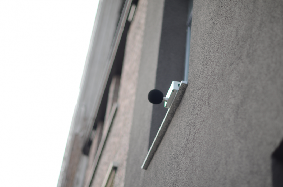 Meetapparaat voor geluidssterkte hangt aan een vensterbank.