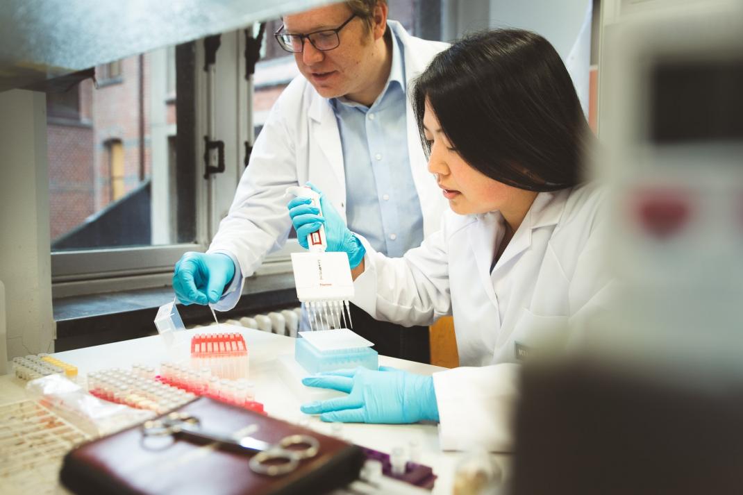 Twee wetenschappers pippeteren in een laboratorium
